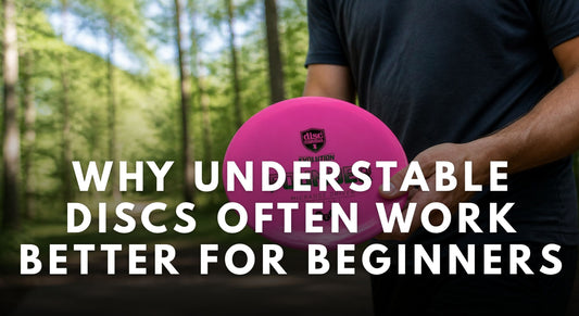 Disc golfer holding a pink understable Discmania Founder before throwing on a wooded fairway.